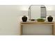 A wooden console table is decorated with lamps and mirror against a white wall at 4730 Bold Peacock Bnd, Bartow, FL 33830