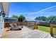 View of backyard from wooden deck with chairs and railing, blue sky at 829 E Lime St, Lakeland, FL 33801