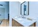 Bathroom featuring wood cabinet, marble countertop, decorative mirror, and wood floors at 829 E Lime St, Lakeland, FL 33801