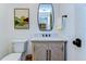 Bathroom featuring wood cabinet, marble countertop, decorative mirror and artwork at 829 E Lime St, Lakeland, FL 33801