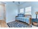 Bright bedroom featuring a blue and white daybed, wood floors, and natural light from the double windows at 829 E Lime St, Lakeland, FL 33801