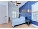 Charming bedroom with light wood floors, modern ceiling fan, and a bright blue accent wall at 829 E Lime St, Lakeland, FL 33801