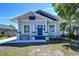 Charming bungalow with blue door, bench seating on the front porch, and mature landscaping at 829 E Lime St, Lakeland, FL 33801