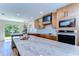 Spacious kitchen with stainless steel appliances, granite countertops, and natural wood cabinetry at 829 E Lime St, Lakeland, FL 33801