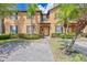 Inviting two-story townhome with a well-manicured lawn, a brick driveway, and beautiful palm trees at 2724 Calabria, Davenport, FL 33897