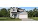 Charming two-story home with a well-manicured lawn, attached two-car garage, and stylish blue front door at 951 Hour Glass Rd, Lakeland, FL 33801