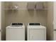 Well-lit laundry area featuring a modern white washer and dryer, convenient wire shelving, and stylish storage baskets at 951 Hour Glass Rd, Lakeland, FL 33801