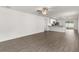 Spacious living room features wood-look floors, a ceiling fan, and an open layout to the kitchen at 1795 White Elephant Loop, Winter Haven, FL 33884