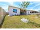 Spacious backyard with white fence, green grass, new tree, and view of home exterior at 3158 Sailing Pier Ave, Winter Garden, FL 34787