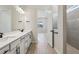 Bright, modern bathroom with double sink vanity and an open doorway to a shower at 3158 Sailing Pier Ave, Winter Garden, FL 34787