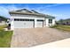 Charming home with a well-manicured lawn, a stone driveway, and a three car garage at 3158 Sailing Pier Ave, Winter Garden, FL 34787