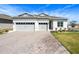 Charming home with a well-manicured lawn, a stone driveway, and a three car garage at 3158 Sailing Pier Ave, Winter Garden, FL 34787