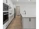 Modern kitchen with stainless appliances, quartz countertops and white shaker cabinets at 3158 Sailing Pier Ave, Winter Garden, FL 34787