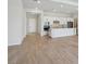 Open-concept living room and kitchen with stainless appliances and light wood-look tile flooring at 3158 Sailing Pier Ave, Winter Garden, FL 34787