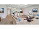 Bright and airy living room featuring a modern kitchen, wood floors, and contemporary furnishings at 3158 Sailing Pier Ave, Winter Garden, FL 34787