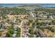 Wide aerial view of a suburban neighborhood with lush greenery and a lake in the distance at 934 W Heron Cir, Winter Haven, FL 33884