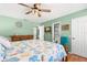 Nautical themed bedroom with ceiling fan, light green walls, wood furnishings, and view to the en suite bathroom at 934 W Heron Cir, Winter Haven, FL 33884