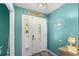Inviting foyer with a white paneled door, nautical decor, and coastal accents on turquoise colored walls at 934 W Heron Cir, Winter Haven, FL 33884