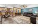 Bright living room flows to kitchen, featuring modern wood flooring and a neutral-toned rug at 934 W Heron Cir, Winter Haven, FL 33884