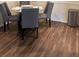 Dining area featuring a glass-topped table with padded chairs and dark wood-look flooring at 3301 Soho St # 102, Orlando, FL 32835