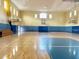 Community gymnasium features multiple basketball hoops, a light floor, and a blue stripe on the walls at 3337 Soho St # 103, Orlando, FL 32835