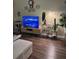 Comfortable living area featuring laminate floors, modern decor, and a large screen television at 3337 Soho St # 103, Orlando, FL 32835