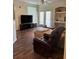 Cozy living room with ceiling fan, wood floors, built in shelves, and sliding glass doors at 3301 Soho St # 102, Orlando, FL 32835
