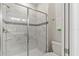 Modern bathroom featuring a tiled shower with a glass door and white fixtures at 1568 Maidstone Ct, Davenport, FL 33896
