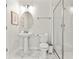Bright bathroom featuring a white pedestal sink, oval mirror, and glass-enclosed shower at 1568 Maidstone Ct, Davenport, FL 33896