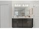 Modern bathroom features a double vanity, large mirror, and plenty of storage space at 1568 Maidstone Ct, Davenport, FL 33896