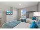 Comfortable bedroom with two twin beds, television, and soothing gray and white walls at 1568 Maidstone Ct, Davenport, FL 33896