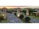 Champions Gate community entrance is illuminated by the warm glow of the sunset, showcasing meticulous landscaping at 1568 Maidstone Ct, Davenport, FL 33896