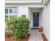 Charming blue front door with decorative bench and a lush hibiscus bush, creating a warm and inviting entryway at 1568 Maidstone Ct, Davenport, FL 33896