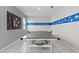Bright game room with tile floors, ping pong table, and fun sports decor at 1568 Maidstone Ct, Davenport, FL 33896