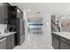 Spacious kitchen with black cabinets, white countertops, stainless steel appliances, and a view to the game room at 1568 Maidstone Ct, Davenport, FL 33896
