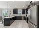 Modern kitchen with black cabinetry, white countertops, stainless steel appliances, and a view to the dining area at 1568 Maidstone Ct, Davenport, FL 33896