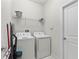 Functional laundry room equipped with a washer, dryer, and storage shelf at 1568 Maidstone Ct, Davenport, FL 33896