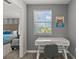 Home office nook with desk, chair, and natural light; bedroom is seen through the doorway at 1568 Maidstone Ct, Davenport, FL 33896