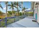 This back deck has light blue paint, a pergola, and stairs down to a grassy yard with palm trees at 515 Frank Lloyd Wright Way, Lakeland, FL 33803