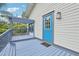 Charming home back porch featuring a blue door, pergola and wooden planks at 515 Frank Lloyd Wright Way, Lakeland, FL 33803