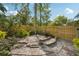 The backyard is surrounded by a wood fence and has a brick-paved sitting area with green shrubs and plants at 515 Frank Lloyd Wright Way, Lakeland, FL 33803