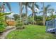 Well-maintained backyard with lush lawn, palm trees and colorful flowers at 515 Frank Lloyd Wright Way, Lakeland, FL 33803