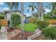 Backyard featuring green grass, brick paths and tropical landscaping at 515 Frank Lloyd Wright Way, Lakeland, FL 33803