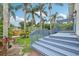 Elevated blue deck and patio area in a landscaped backyard with palm trees at 515 Frank Lloyd Wright Way, Lakeland, FL 33803