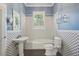 Bathroom featuring black and white tile, pedestal sink, and a tub with shower fixtures at 515 Frank Lloyd Wright Way, Lakeland, FL 33803