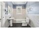 The bathroom features a pedestal sink, a classic-style toilet, and a tub at 515 Frank Lloyd Wright Way, Lakeland, FL 33803