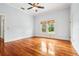 Comfortable bedroom with a ceiling fan, large window for natural light, and hardwood floor at 515 Frank Lloyd Wright Way, Lakeland, FL 33803