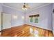 Bedroom with hardwood floors, sconces, a window, and a ceiling fan at 515 Frank Lloyd Wright Way, Lakeland, FL 33803