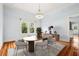 Elegant dining room with hardwood floors, chandelier, and views of the landscaped yard at 515 Frank Lloyd Wright Way, Lakeland, FL 33803