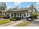 Quaint home featuring a covered porch, manicured landscaping, and a patterned driveway at 515 Frank Lloyd Wright Way, Lakeland, FL 33803